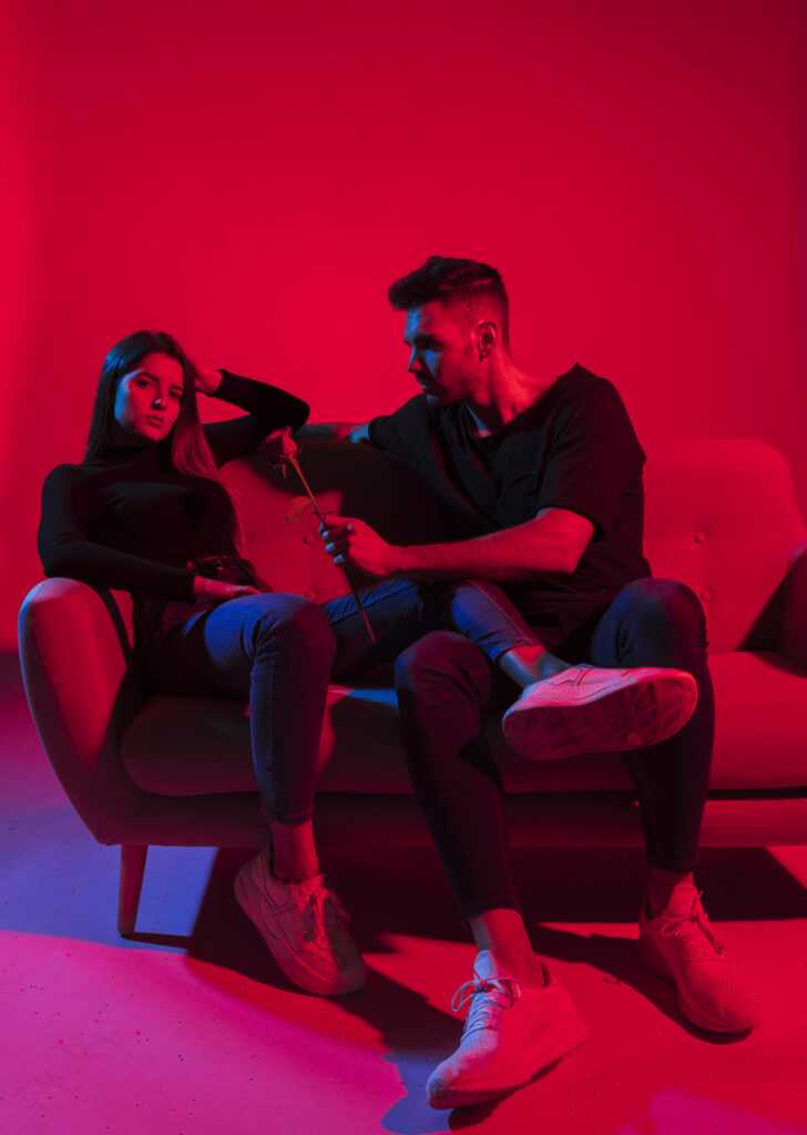 young-man-giving-rose-flower-woman-couch