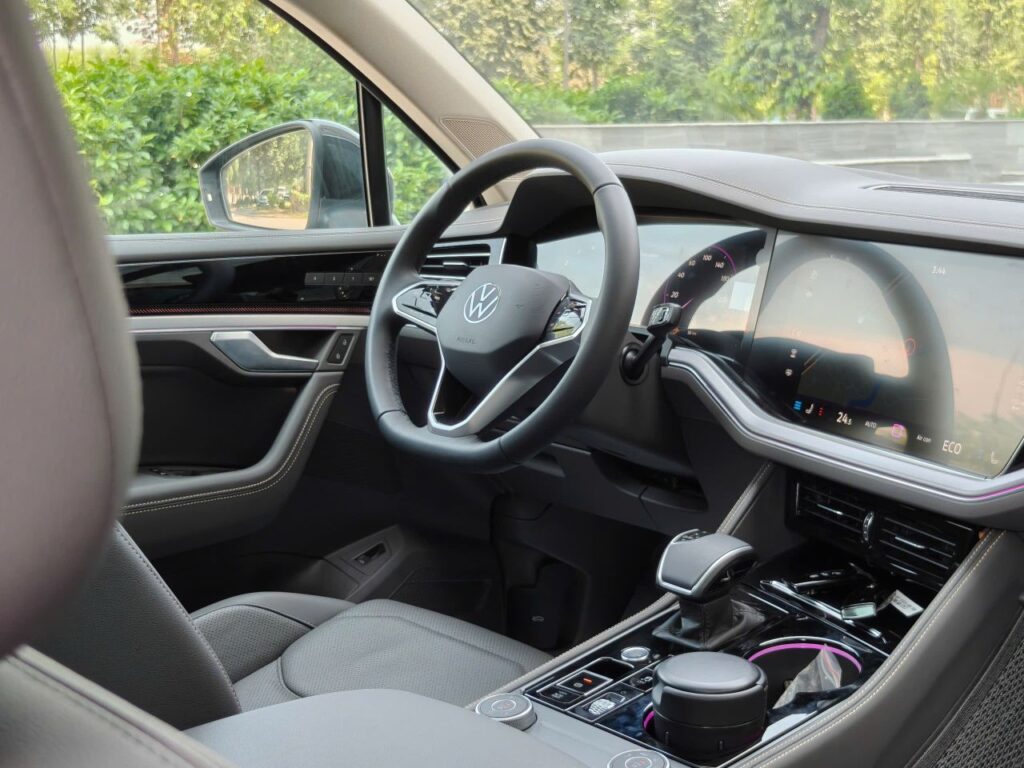 Sleek car interior showcasing a digital dashboard and steering wheel.